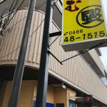 Picture shows a sign for the business on the first level and the balcony for the second floor apartment